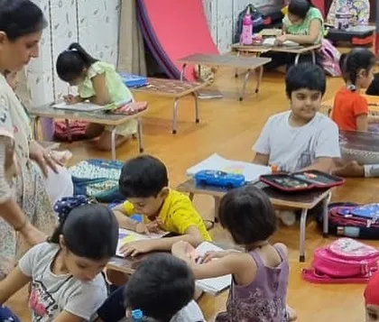 A teacher providing guidance during a drawing class. I ensure a high teacher-to-student ratio so everyone gets the help they need.