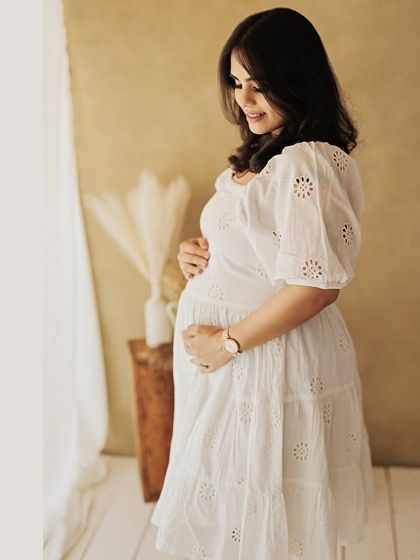 A solo portrait of the mother-to-be, looking down at her bump with a gentle smile. A moment of pure connection.