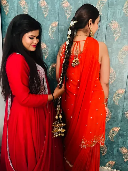 Me helping a client style her hair with a traditional parandi, showing how it enhances the overall ethnic look.