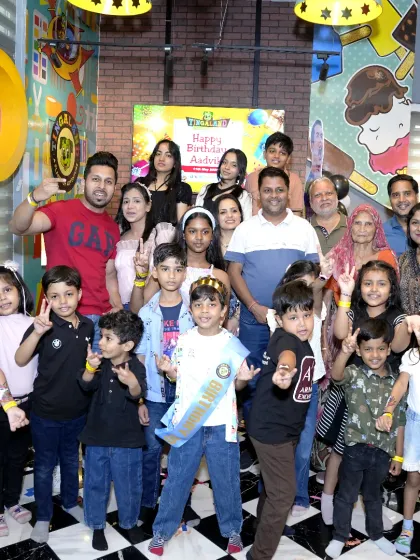 The whole gang is here! A birthday boy is surrounded by his friends and family for a big group photo to remember his special day.