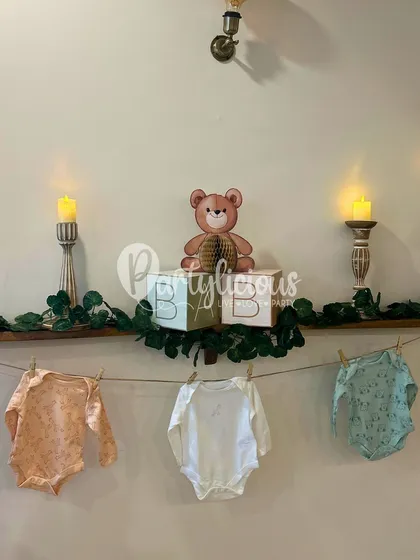 Adorable details from a baby shower, including 'BABY' blocks, tiny clothes on a line, and soft candlelight.