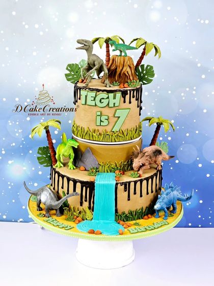 A studio shot of the two-tier dinosaur cake, showcasing the chocolate drip "mud" and the detailed prehistoric landscape.