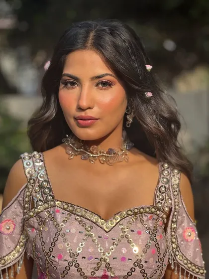 A soft, romantic look perfect for a daytime Mehendi or carnival event. I focused on creating dewy skin that glows in the sunlight, paired with a hint of pink on the eyes and lips, and whimsical flowers woven into her hair.