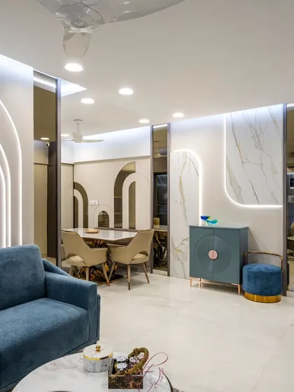 This living and dining space is defined by its soft, curved motifs and luxurious materials. We used arched, backlit wall panels and marble accents to create a sense of modern elegance and fluidity.