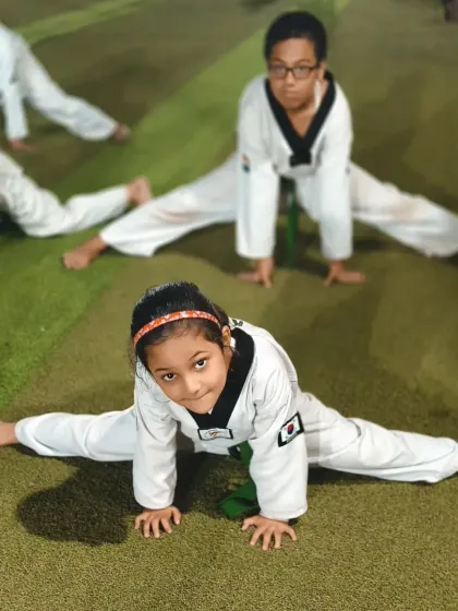 A young student proudly shows off her center split. This level of flexibility is a direct result of her hard work and consistent practice in class.