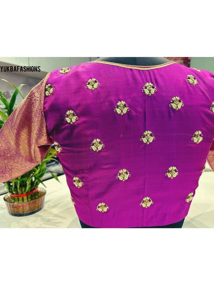 A simple and elegant magenta blouse with scattered floral buttis embroidered on the back, made for a client's special request.
