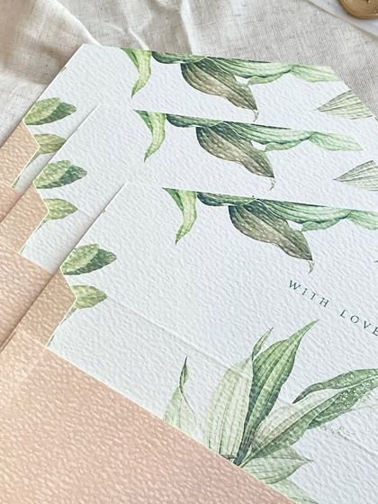A detail shot of the custom-printed envelope liners, featuring a watercolor green leaf pattern. Liners are a wonderful way to add a hidden pop of color and personality to your invitation.