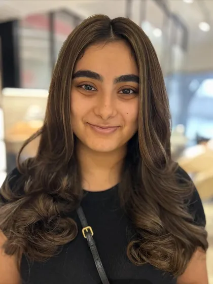 The client's happy expression with her new classic highlights. The color is bright and beautiful, and the style is perfectly polished.