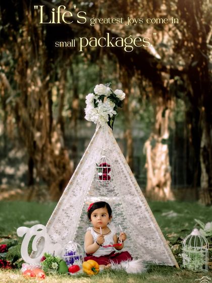 Life's greatest joys come in small packages. A beautiful portrait of a baby girl in a red and white dress, enjoying her first birthday teepee session.