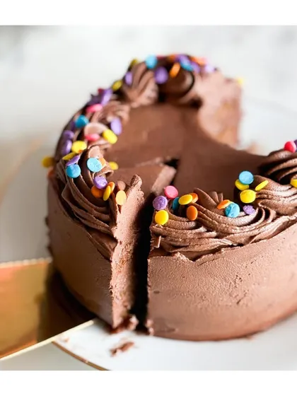 A slice of pure happiness. The colorful confetti sprinkles add a touch of fun to the rich chocolate layers of this delicious cake.