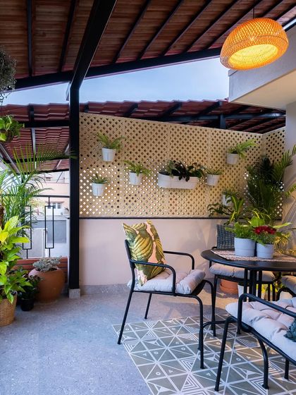 Even a small terrace can become a lush retreat. We used a combination of potted plants, a patterned floor, and a slatted roof to create a charming outdoor dining area that feels connected to nature.