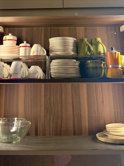 A cabinet dedicated to coffee and tea essentials. We've used risers to stack plates and mugs, leaving space for a moka pot and other accessories.
