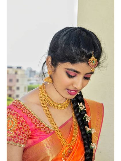 A close-up of the makeup, featuring shimmery pink eyeshadow and a matching lip color. This soft glam approach is perfect for clients who want a traditional but not overly heavy look.