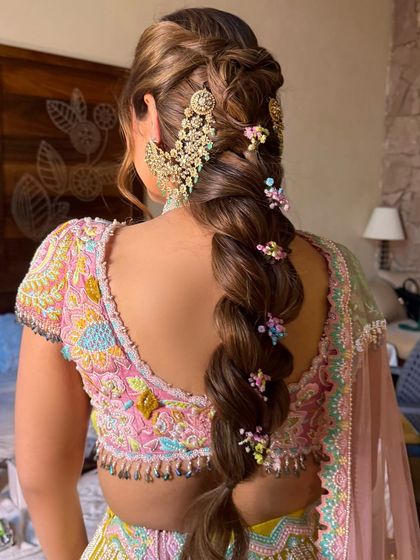 The back view of the bubble plait, highlighting the colorful floral details and the large, statement hair jewelry.