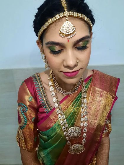 This close-up focuses on the eye makeup for the Varapooja look, showing the blend of colors and the dramatic false lashes.