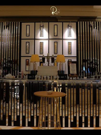 A custom bar with a black and white striped facade and a modern, illuminated back bar.