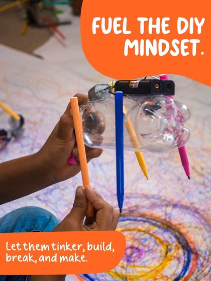 A child holds their Art Bot, made from a recycled plastic bottle, demonstrating our principle of seeing possibility in everyday objects.