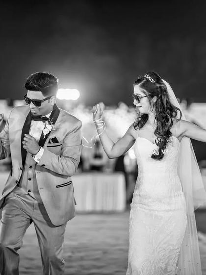 A powerful, synchronized pose from the couple during their reception entrance. This black and white shot is full of confidence and energy.