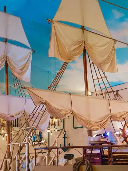 The sails and masts of the ship bar, set against a painted sky ceiling. This detail was key to creating the illusion of being on a grand sailing vessel.
