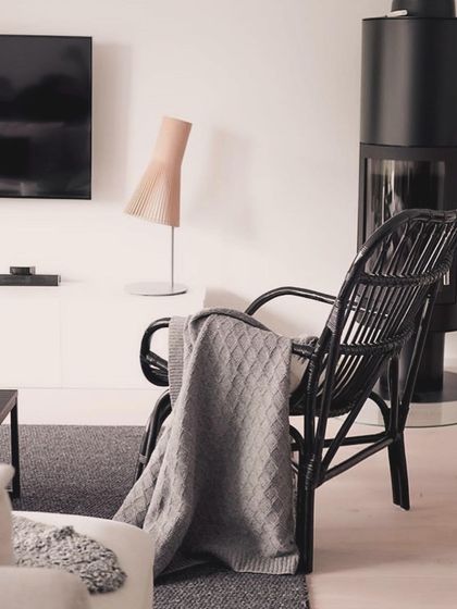 A Secto table lamp in a natural birch finish provides a soft, warm accent light in a cozy, contemporary living room.