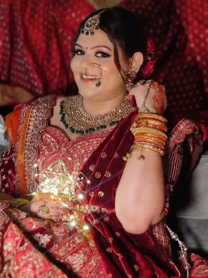 A happy moment captured. Agrima's soft glam makeup perfectly complements her intricately embroidered velvet lehenga.