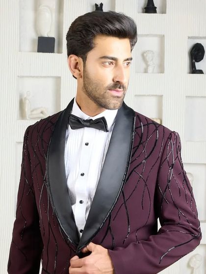 This wine-colored tuxedo is designed for distinction. The deep hue is complemented by abstract black beadwork and a contrasting black silk shawl lapel, creating a look of modern luxury for any formal event.