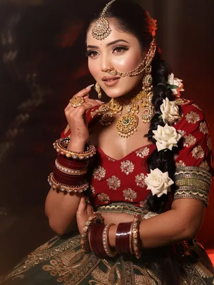 A classic red and green bridal look. The braided hair with white roses adds a touch of softness.