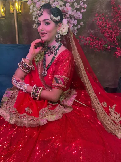 The full seated view of this red bridal lehenga shows its beautiful drape and volume. It’s a fantastic choice for brides who want a classic yet glamorous outfit.