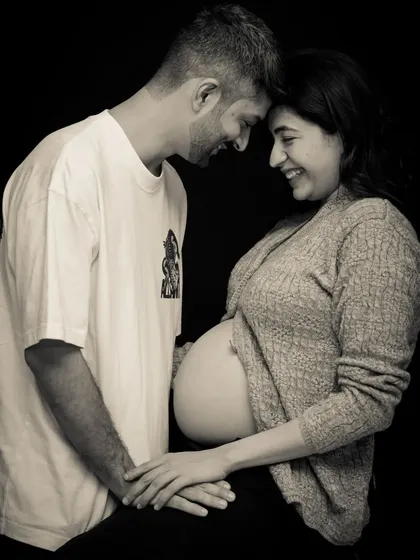 A joyful and candid black and white photo. This couple shares a laugh, their foreheads touching, in a moment of pure, unscripted happiness.