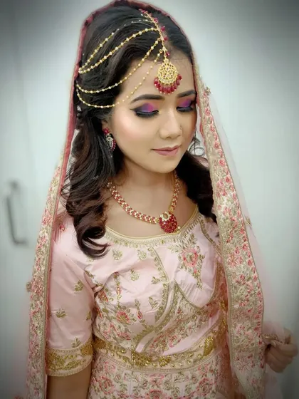 A close-up of a modern bridal look with a focus on dramatic eye makeup using purple and pink tones. Students learn color theory and blending techniques to create custom looks for their clients.