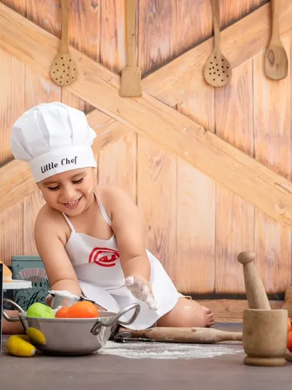 Let's get cooking. In my popular "Little Chef" themed session, your child can play and explore in a rustic kitchen setup. This little chef is completely absorbed in his work, making for a candid and personality-filled photograph.