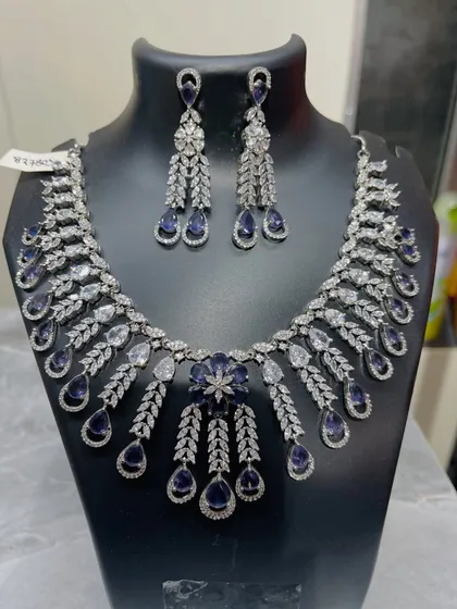 For a touch of classic elegance, this stunning necklace and earring set is a perfect choice. The intricate design combines brilliant clear crystals with deep sapphire-blue stones, making it an ideal rental for your reception or a formal evening party.