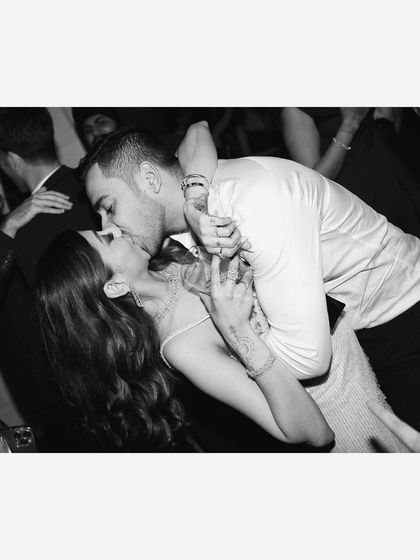 The exhilarating dip and kiss on a packed dance floor. This black and white shot captures the peak energy of the celebration, a moment of passionate, cinematic romance amidst the party.