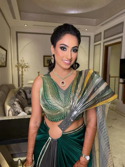 A full-length shot of this sangeet glam look. The modern green saree is paired beautifully with soft, shimmering makeup for an elegant and festive style.