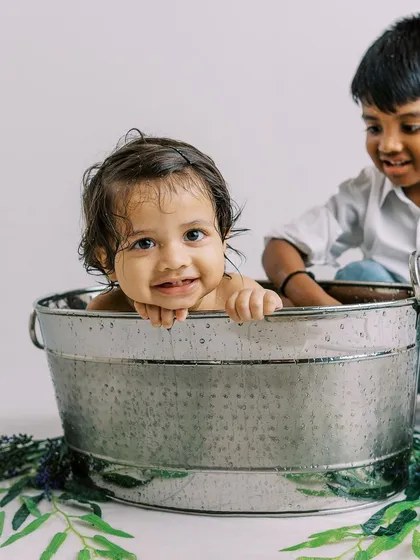 A splash session is even more fun with a big brother to help. This sweet moment of sibling interaction is just priceless.