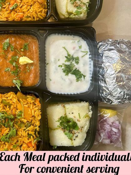 Convenience is key for large gatherings. Each meal is packed individually, like this one with Pav Bhaji, Tawa Pulao, and Dhokla, making serving easy and hygienic for a housewarming dinner.