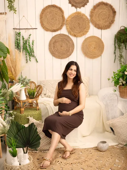A relaxed and happy portrait in my natural-light studio. The earthy tones and abundance of plants create a calm and organic setting for this beautiful mother-to-be.