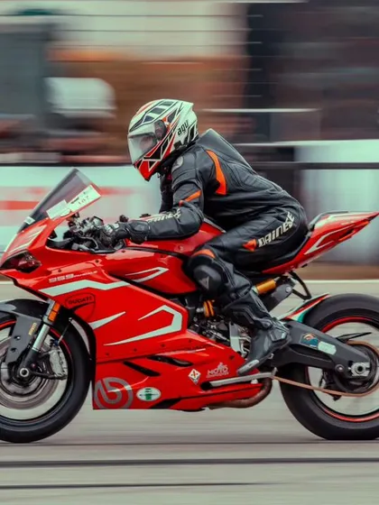 A red Ducati Panigale, the pinnacle of Italian performance, captured in a dynamic panning shot. We attract the most exotic and desirable superbikes to our events.