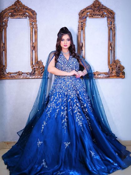 A full-length portrait that highlights the flowing cape and intricate embroidery.