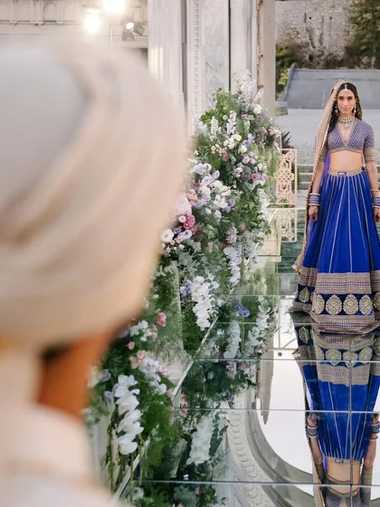 This is the moment we plan for. The quiet anticipation as the groom sees his bride for the first time, walking down a mirrored aisle that reflects the sky above. We craft these emotional first looks with precision, ensuring the setting is as profound as the feeling.