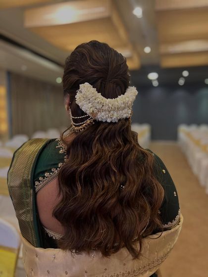 The back view of a classic Maharashtrian bridal hairstyle, featuring a beautiful bun adorned with fresh mogra flowers.