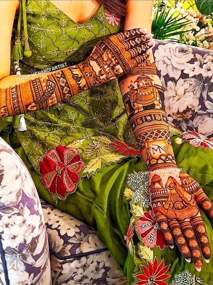 A close-up shot of a bride's hands, showing the detailed patterns and personalized initials on her arms.