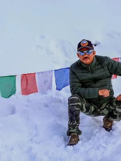 Taking a moment in the snow at Khardungla, surrounded by prayer flags. These races are as much a spiritual journey as a physical one.