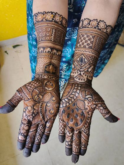 A stunningly detailed design combining many traditional elements. You can see peacocks, elephants, lotuses, and jhumkas all woven together into a cohesive and breathtaking bridal mehendi.