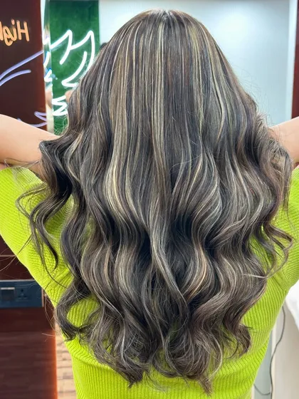Another shot of the back of this stunning ash blonde balayage, with the salon's neon sign in the background.
