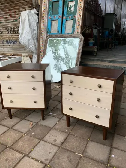 A pair of mid-century style three-drawer chests or nightstands with a two-tone finish.