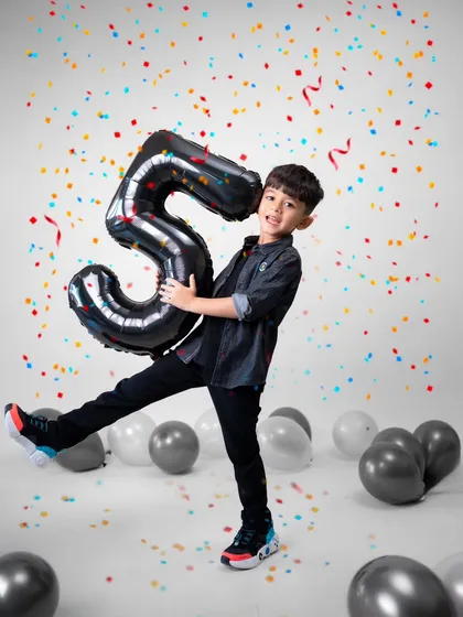 Celebrating a milestone like turning five should be full of energy and joy. I designed this studio setup with bright confetti and balloons to match his vibrant personality. My goal is to capture the pure, unscripted happiness of the moment, creating a memory as lively as the celebration itself.