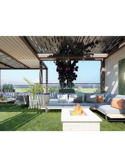 A closer look at the fire pit and seating area, showing the comfortable cushions and pillows that make the space inviting. The green wall in the background adds a touch of nature.