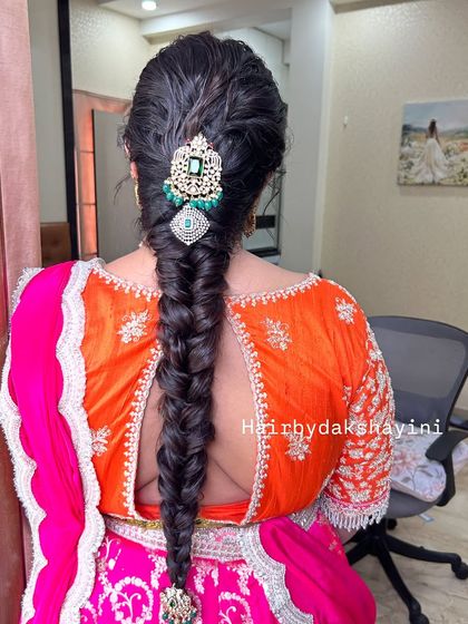 A clear, centered shot of the fishtail braid with a statement emerald and diamond hair accessory.