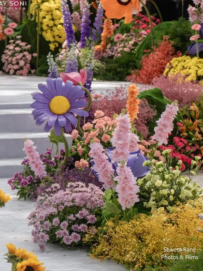 A detail shot of the vibrant, multi-colored floral arrangements used along the aisle, showcasing the incredible variety of blooms.
